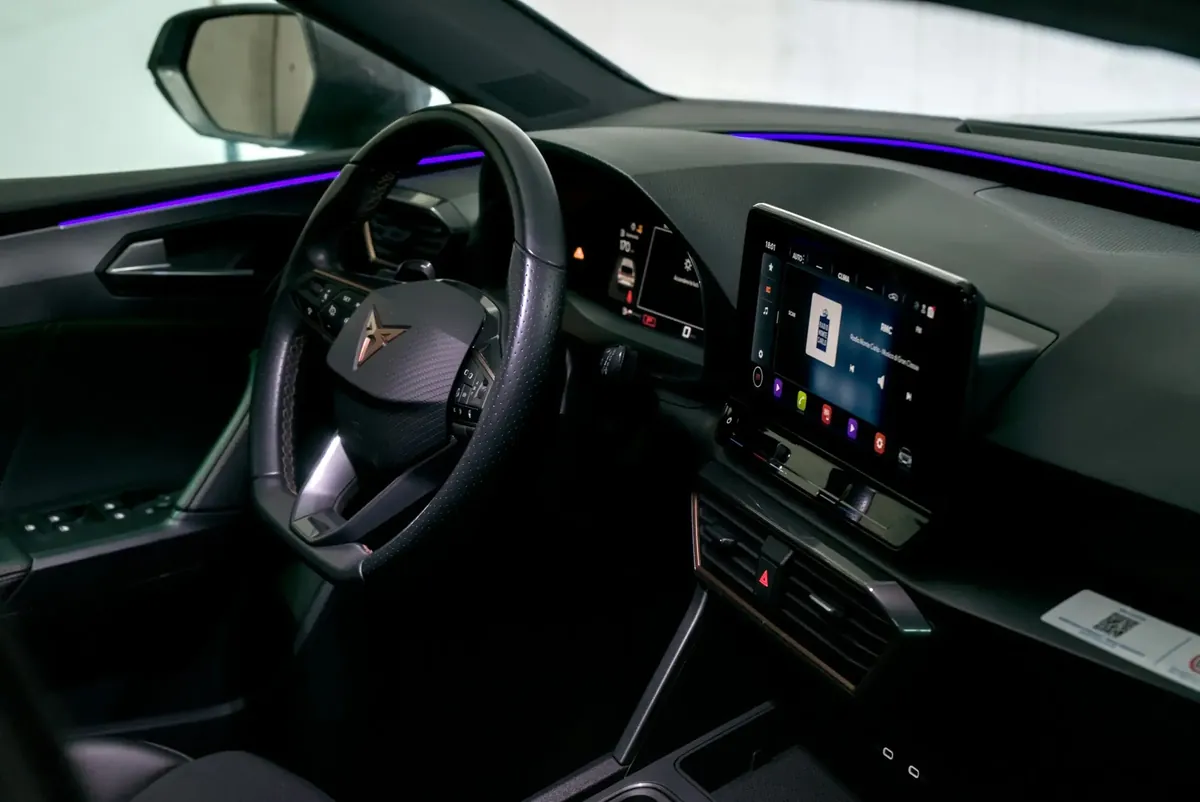 The same dashboard and door panel with a violet ambient light line switched on