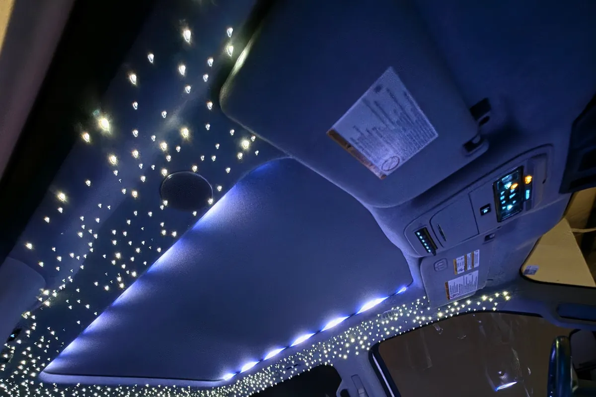 Fiber-optic stars and blue sunroof lighting across a Ford Super Duty headliner