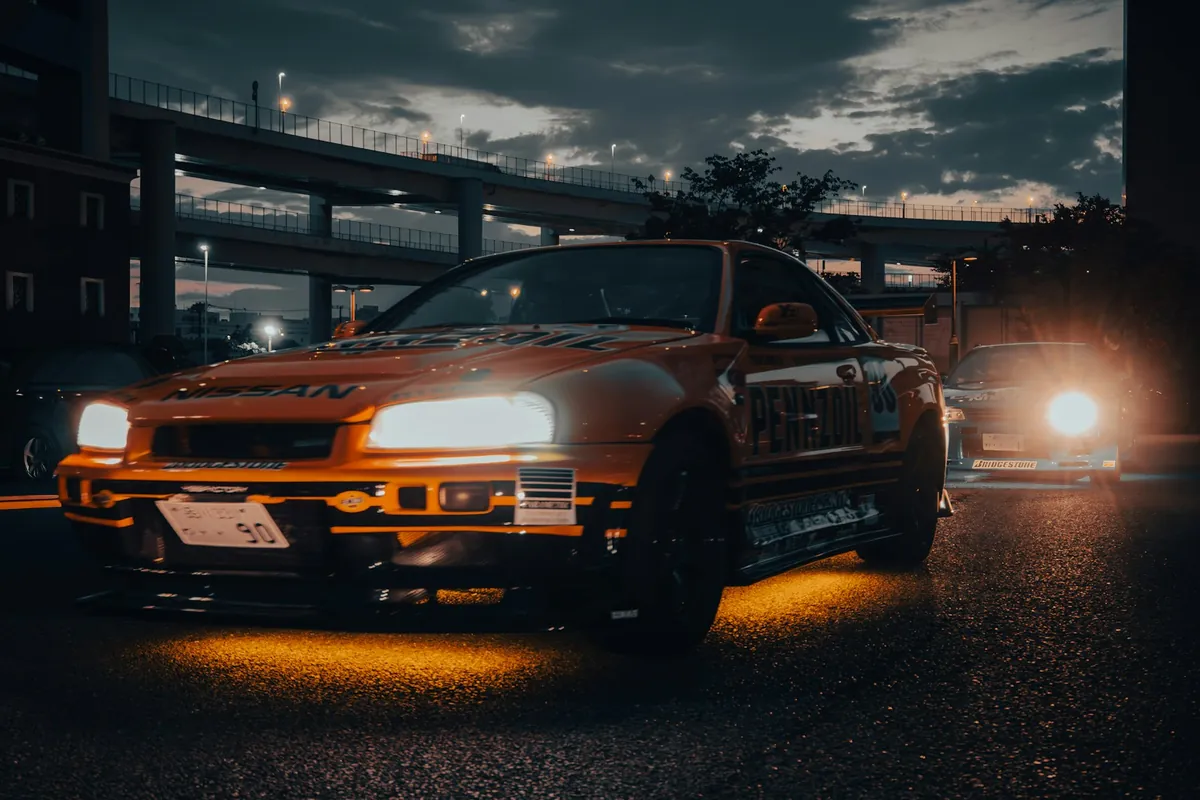 Amber underglow under the front of a sports car at night